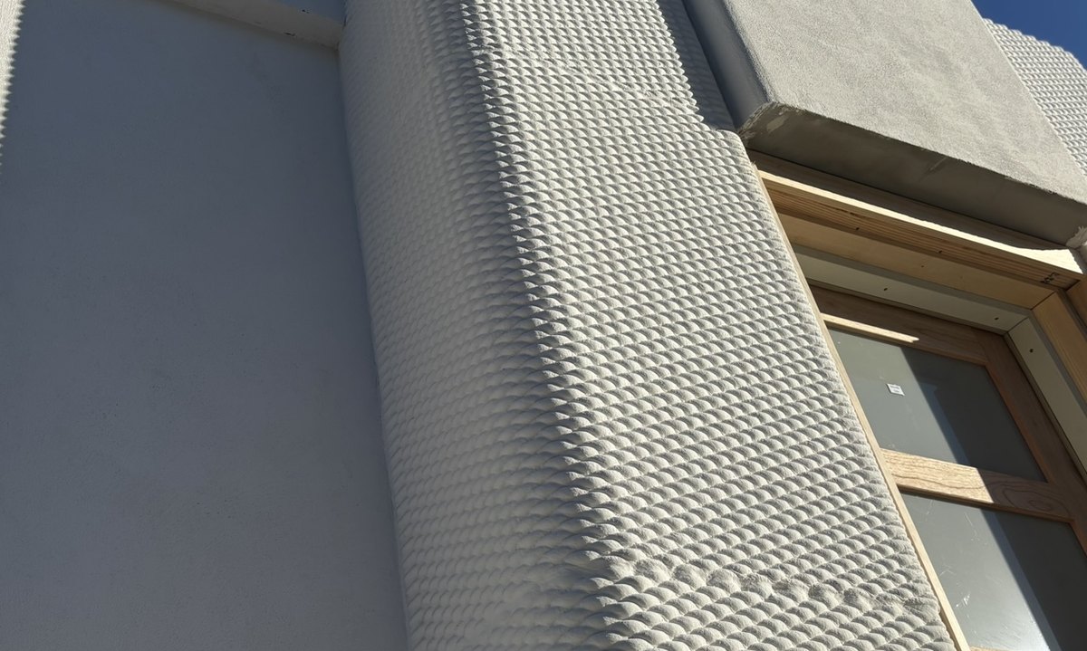 Printed facade pilaster with a parametric surface texture on a finished building