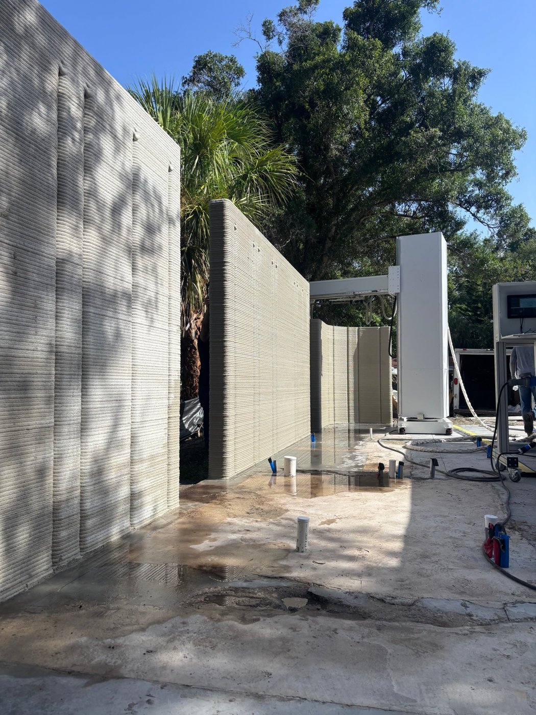 ATLAS tower printer on a residential jobsite beside freshly printed walls